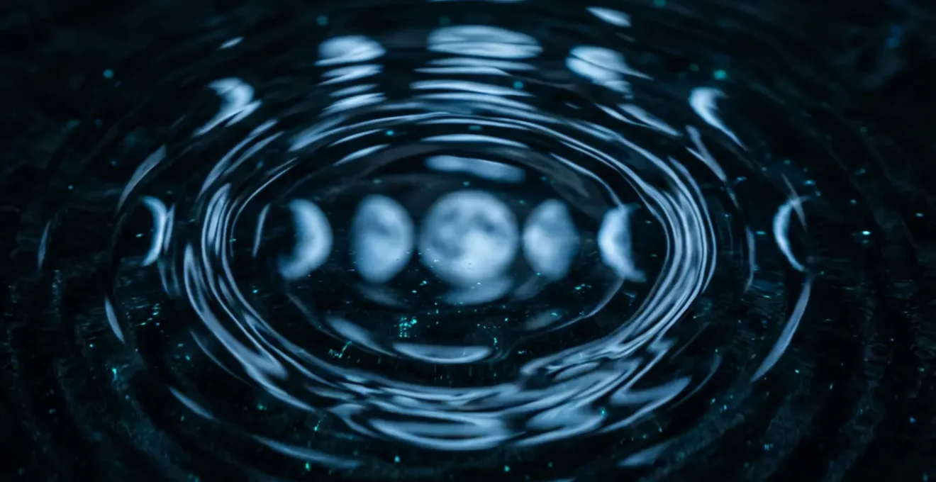 Fasi lunari riflesse in uno specchio d'acqua da cui emergono figure oniriche, a simboleggiare il legame tra la Luna e il mondo dei sogni.